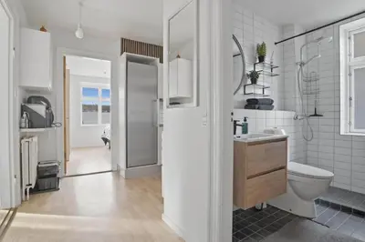 a white bathroom with a toilet and a sink at Apartment in central Holstebro in Holstebro