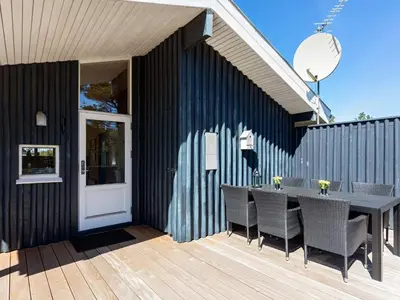 a patio with a table and chairs on a deck at 6 person holiday home in Pandrup-By Traum in Pandrup
