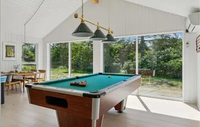 a pool table in a living room with a pool at Nice Home In Blokhus With Kitchen in Blokhus