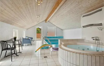 a large bathroom with a tub and a table and chairs at Nice Home In Vinderup With Sauna in Vinderup