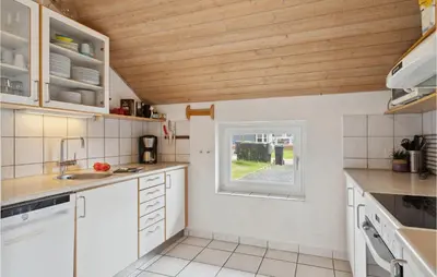 a kitchen with white cabinets and a window at Nice Home In Vinderup With Sauna in Vinderup
