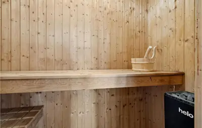 a wooden shelf in a sauna with a bucket at Nice Home In Vinderup With Sauna in Vinderup