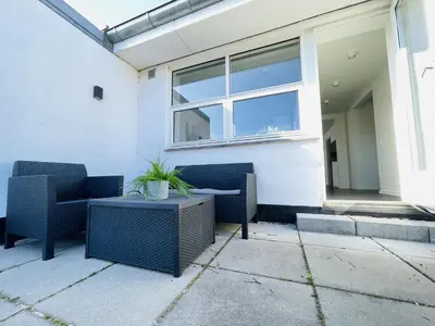 a patio with two chairs and a table in front of a building at aday - Elegant Apartment with Terrace in Svenstrup