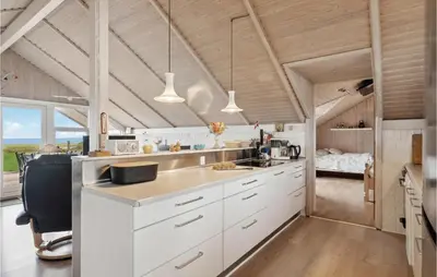 a kitchen with white cabinets and a large window at 3 Bedroom Cozy Home In Løgstør in Løgsted