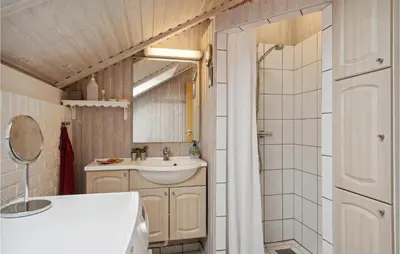 a bathroom with a sink and a toilet and a shower at 3 Bedroom Cozy Home In Løgstør in Løgsted