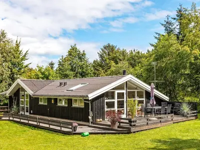 a black house with a deck and a yard at 6 person holiday home in Fjerritslev-By Traum in Fjerritslev
