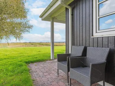 a patio with two chairs on the side of a house at 4 person holiday home in Thisted-By Traum in Thisted
