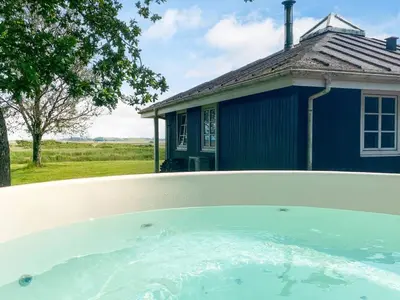a swimming pool in front of a blue house at 4 person holiday home in Thisted-By Traum in Thisted
