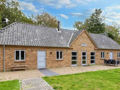 a brick house with a white door in a yard at 8 person holiday home in Thyholm-By Traum in Thyholm