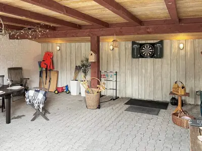 a patio with a table and chairs and a wooden ceiling at 8 person holiday home in Thyholm-By Traum in Thyholm