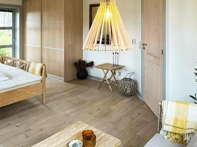a bedroom with a bed and a table and a chandelier at 8 person holiday home in Thyholm-By Traum in Thyholm