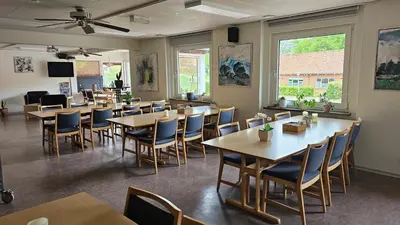 a restaurant with tables and chairs in a room at Gudum Park in Lemvig