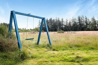 an old swing set in a field of grass at Skytten 5 - Environmentally Friendly Holiday Home in Hune