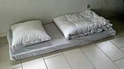 a bed with two pillows sitting on the floor at Stort værelse med tekøkken, tæt på hav og fjord. in Bedsted Thy
