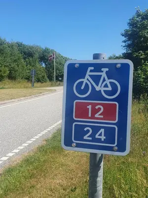 a blue bike sign on the side of a road at Stort værelse med tekøkken, tæt på hav og fjord. in Bedsted Thy
