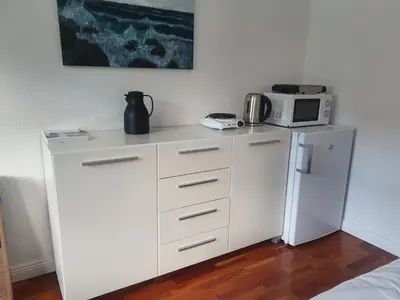a kitchen with a white refrigerator and a microwave at Stort værelse med tekøkken, tæt på hav og fjord. in Bedsted Thy