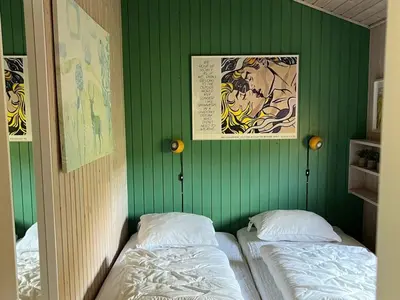 a green wall with two beds in a room at Holiday Home Riitta - 300m from the sea by Interhome in Løkken