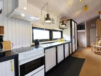 a kitchen with white cabinets and a stove top oven at Holiday Home Riitta - 300m from the sea by Interhome in Løkken