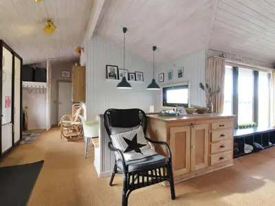 a living room with a chair and a desk at Holiday Home Riitta - 300m from the sea by Interhome in Løkken