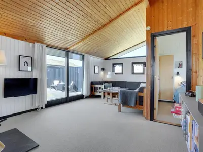 a living room with a television and a living room with a table at Holiday Home Ilmari - 190m from the sea by Interhome in Pandrup