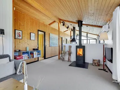 a living room with a fireplace and a couch at Holiday Home Ilmari - 190m from the sea by Interhome in Pandrup