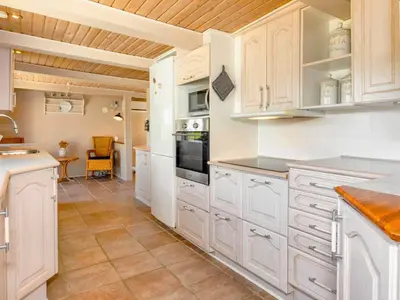 a large kitchen with white cabinets and a table at 5 person holiday home in Karby-By Traum in Karby