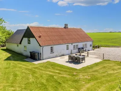 a white building with a red roof in a field at 5 person holiday home in Karby-By Traum in Karby