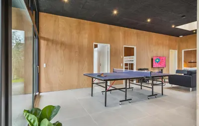 a ping pong table in a room with a couch at Lovely Home In Højslev With Sauna in Højslev