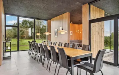 a dining room with a long table and chairs at Lovely Home In Højslev With Sauna in Højslev