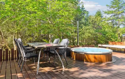 a deck with a table and chairs and a hot tub at Lovely Home In Hurup Thy in Sønder Ydby