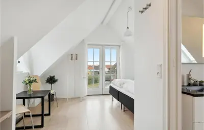 a white living room with a bed and a desk at Beautiful Home In Blokhus in Blokhus
