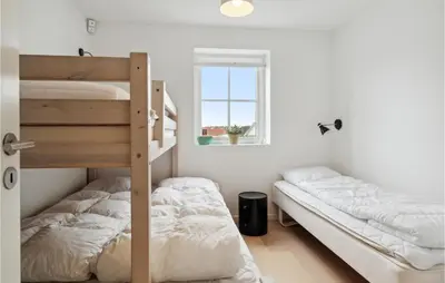 a bedroom with two bunk beds and a window at Beautiful Home In Blokhus in Blokhus