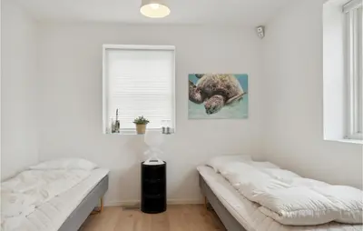 a bedroom with two beds and a window at Beautiful Home In Blokhus in Blokhus