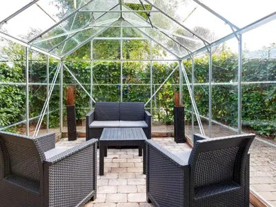 a glass greenhouse with two chairs and a table at 6 person holiday home in Thisted-By Traum in Thisted