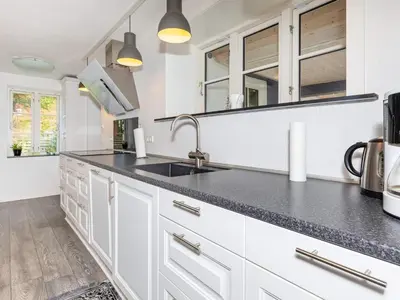 a kitchen with white cabinets and a black counter top at 6 person holiday home in Thisted-By Traum in Thisted