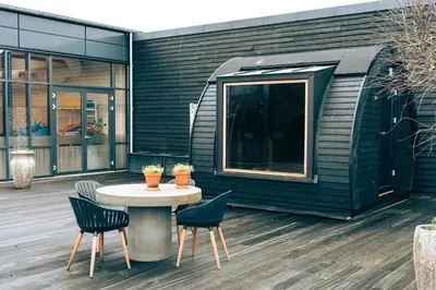 a patio with a table and chairs and a building at Nice holiday home in beautiful resort in Farsø