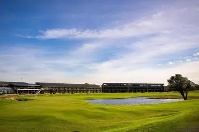 a golf course with a pond in front of a building at Nice holiday home in beautiful resort in Farsø