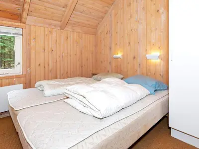 a large bed in a room with wooden walls at 8 person holiday home in Fjerritslev-By Traum in Fjerritslev