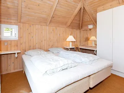 a large bed in a room with wooden walls at 8 person holiday home in Fjerritslev-By Traum in Fjerritslev