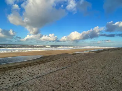 a sandy beach with waves in the ocean at 9 person holiday home in Harboøre-By Traum in Harboør