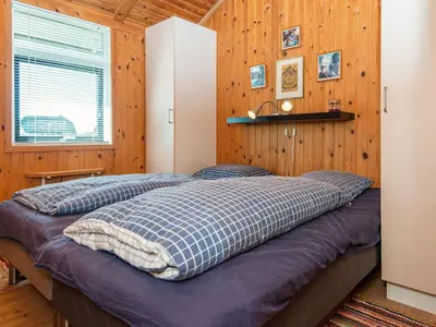 a bedroom with a bed in a wooden wall at 9 person holiday home in Harboøre-By Traum in Harboør