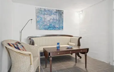a living room with a couch and a table and chairs at Beautiful Apartment In Hurup Thy in Heltborg