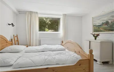 a bed in a white bedroom with a window at Beautiful Apartment In Hurup Thy in Heltborg