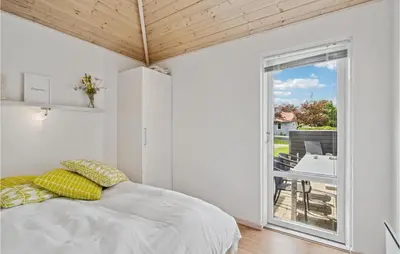 a bedroom with a bed and a large window at 3 Bedroom Lovely Home In Farsø in Farsø