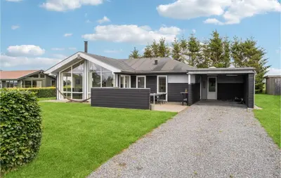 a house with a lawn in front of it at 3 Bedroom Lovely Home In Farsø in Farsø