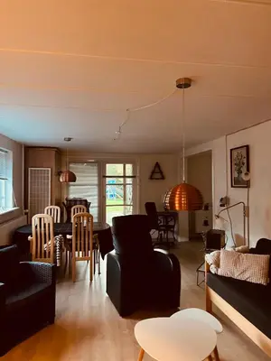 a living room with black furniture and a dining room at Gittes hus in Skive