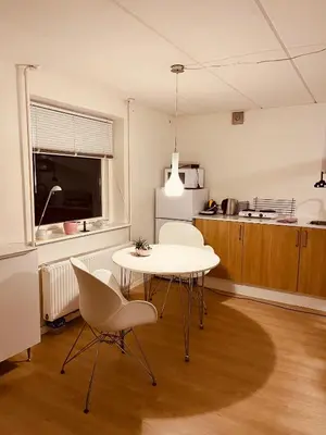 a kitchen with a table and chairs in a room at Gittes hus in Skive