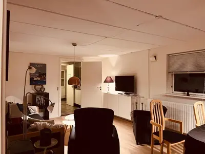 a living room with a couch and a table and chairs at Gittes hus in Skive
