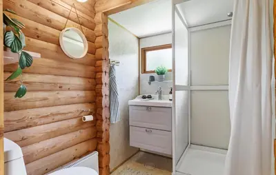a bathroom with a wooden wall with a shower at Lovely Home In Højslev With Kitchen in Lundø