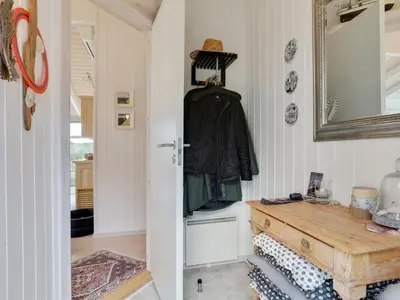 a hallway with a mirror and a wooden table at Holiday Home Lennja - 300m from the sea by Interhome in Saltum